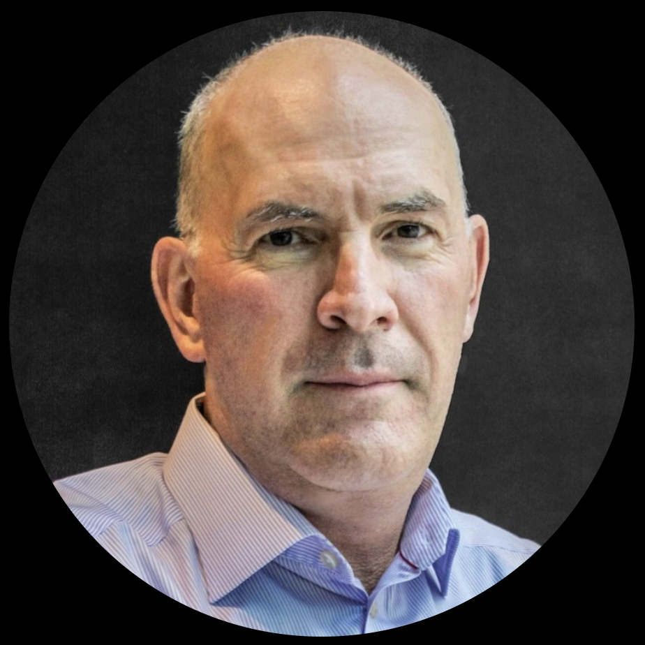 Portrait of a bald man with a serious expression, wearing a striped shirt, against a black background