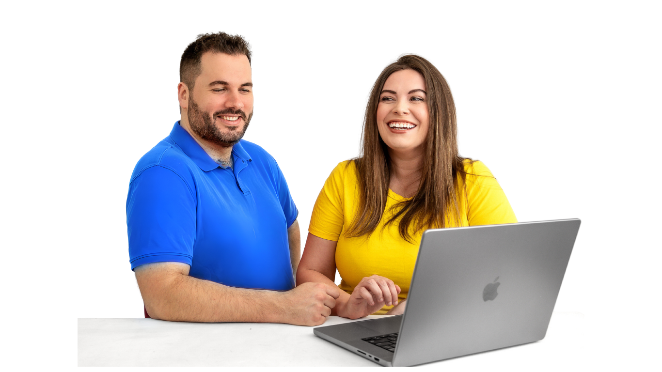 A man in a blue shirt and a woman in a yellow shirt laughing and looking at a laptop screen together, isolated on a white background
